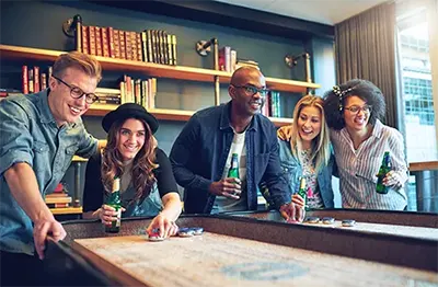 Group of friends playing shuffleboard in the Game Lounge